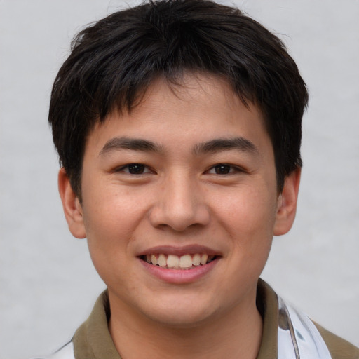 Joyful asian young-adult male with short  brown hair and brown eyes