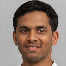 Joyful latino young-adult male with short  black hair and brown eyes