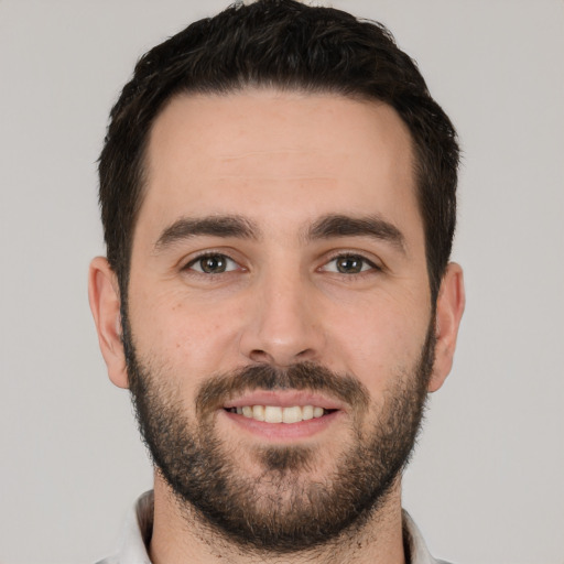 Joyful white young-adult male with short  black hair and brown eyes