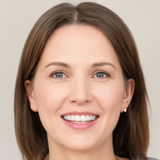 Joyful white young-adult female with medium  brown hair and grey eyes