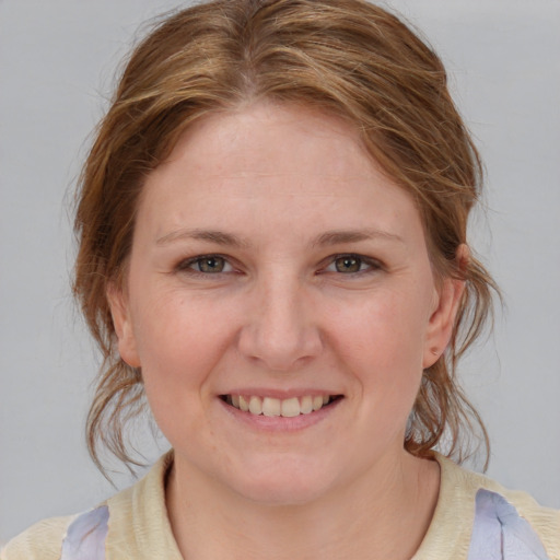 Joyful white young-adult female with medium  brown hair and blue eyes