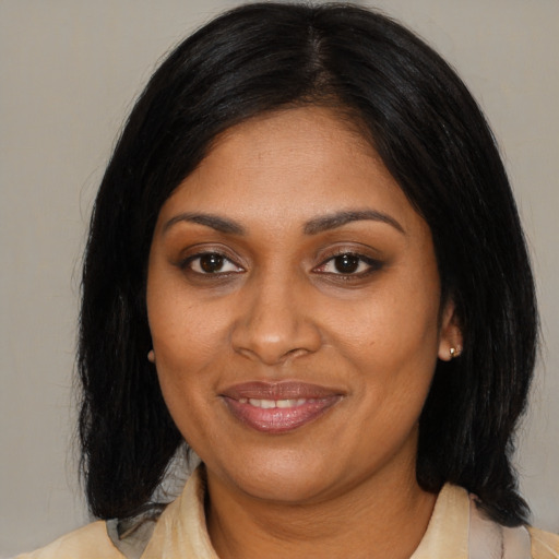 Joyful black adult female with medium  black hair and brown eyes