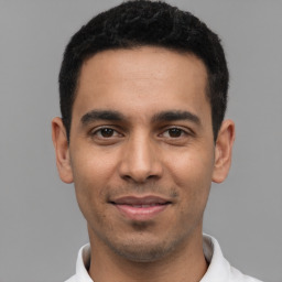 Joyful latino young-adult male with short  black hair and brown eyes