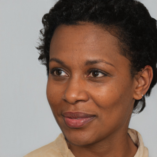 Joyful black adult female with short  brown hair and brown eyes