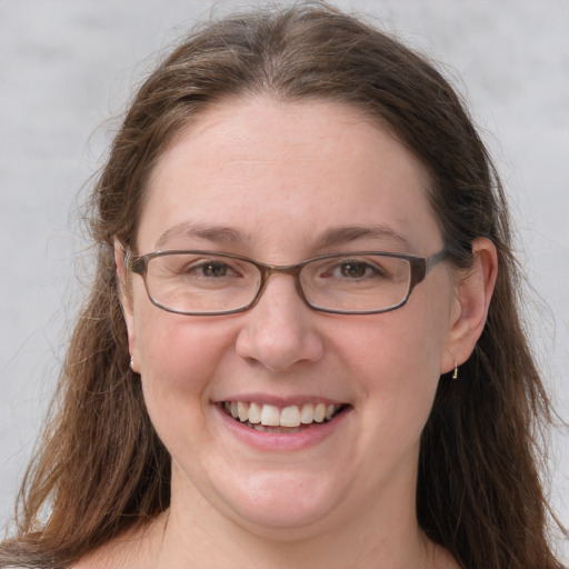 Joyful white adult female with long  brown hair and grey eyes