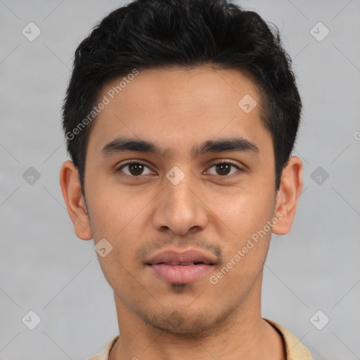 Joyful latino young-adult male with short  brown hair and brown eyes