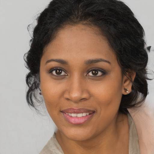 Joyful black young-adult female with long  brown hair and brown eyes