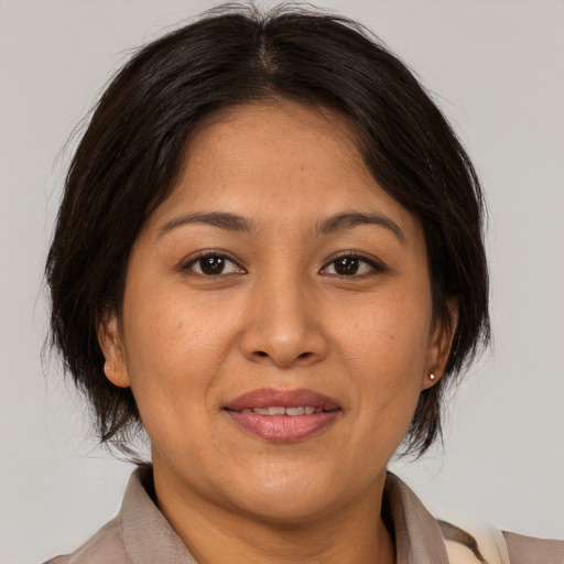 Joyful asian adult female with medium  brown hair and brown eyes