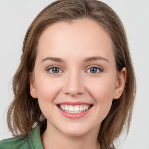 Joyful white young-adult female with medium  brown hair and blue eyes