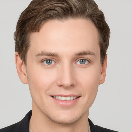 Joyful white young-adult male with short  brown hair and grey eyes