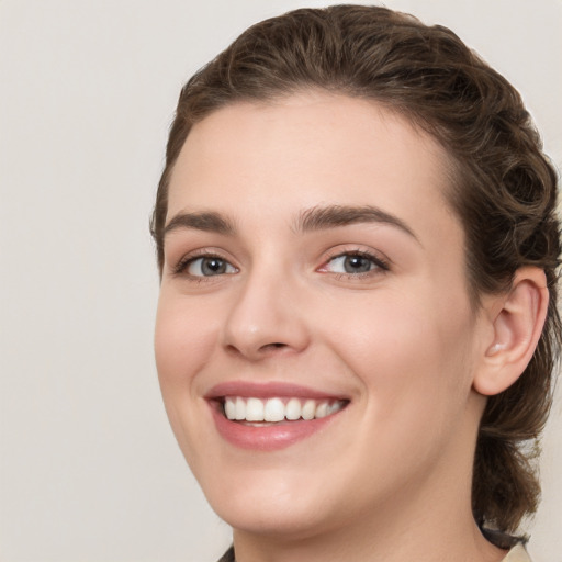 Joyful white young-adult female with medium  brown hair and green eyes