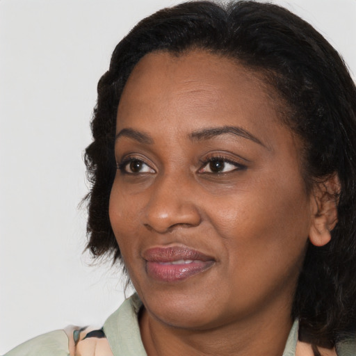 Joyful black adult female with medium  brown hair and brown eyes