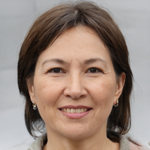 Joyful white adult female with medium  brown hair and brown eyes