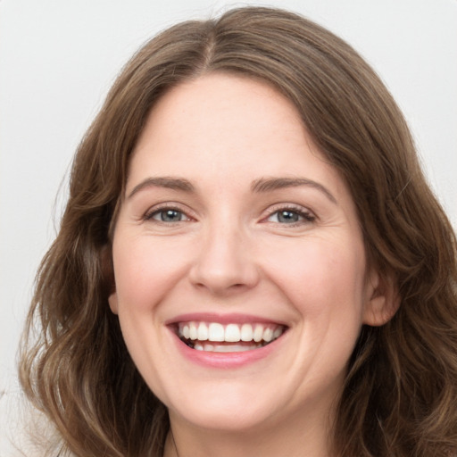 Joyful white young-adult female with long  brown hair and green eyes