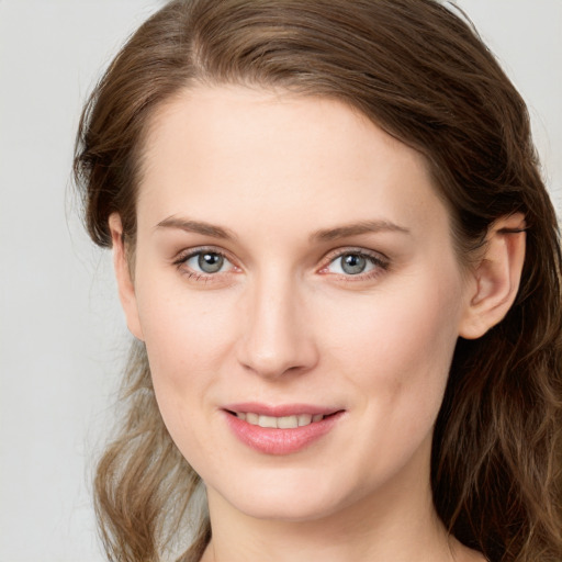 Joyful white young-adult female with long  brown hair and blue eyes