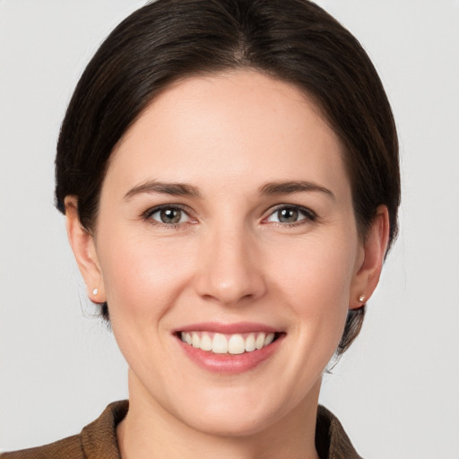 Joyful white young-adult female with medium  brown hair and grey eyes