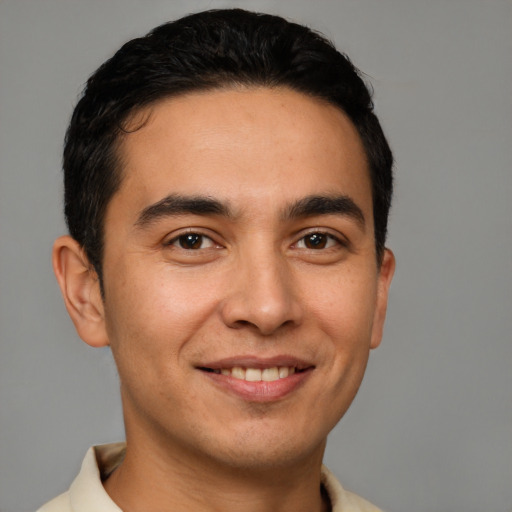 Joyful latino young-adult male with short  brown hair and brown eyes