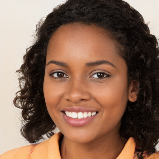 Joyful black young-adult female with long  brown hair and brown eyes