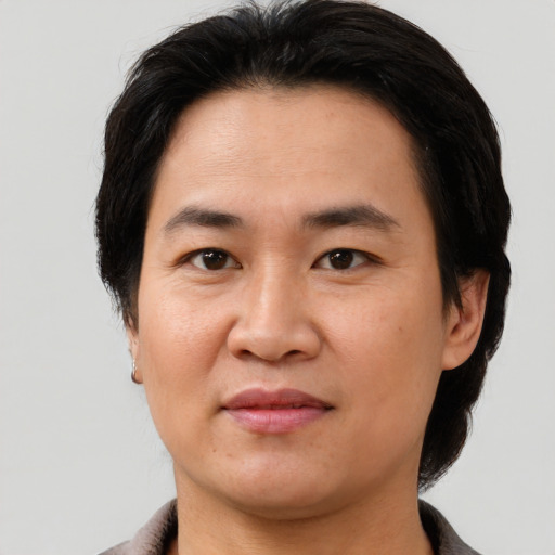 Joyful asian adult male with short  brown hair and brown eyes