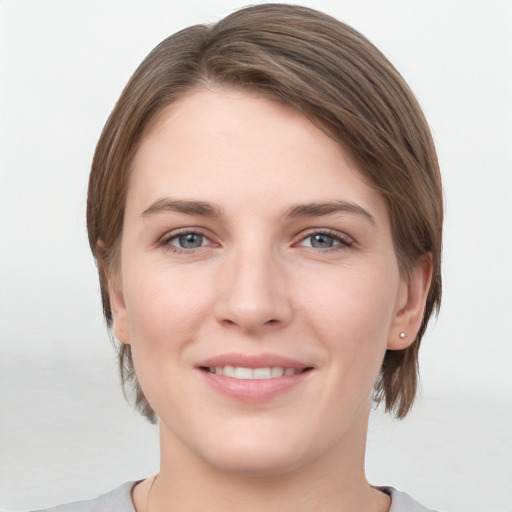 Joyful white young-adult female with medium  brown hair and grey eyes