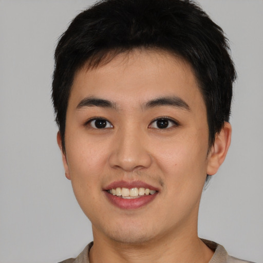 Joyful asian young-adult male with short  brown hair and brown eyes