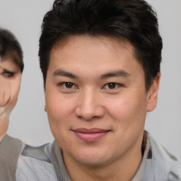 Joyful asian young-adult male with short  brown hair and brown eyes