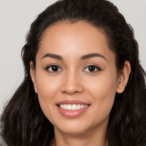 Joyful latino young-adult female with long  black hair and brown eyes