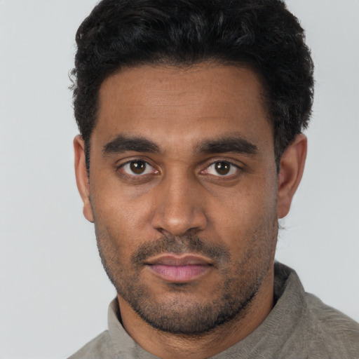 Joyful black young-adult male with short  black hair and brown eyes