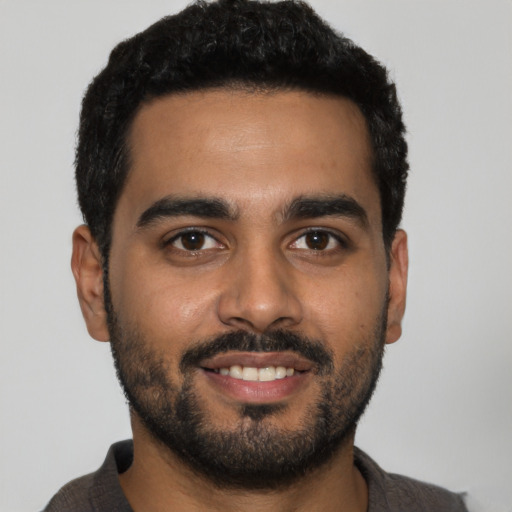 Joyful latino young-adult male with short  black hair and brown eyes