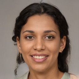 Joyful latino young-adult female with medium  brown hair and brown eyes