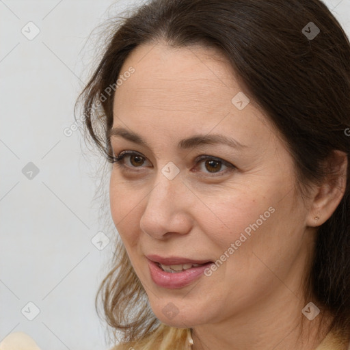 Joyful white adult female with medium  brown hair and brown eyes