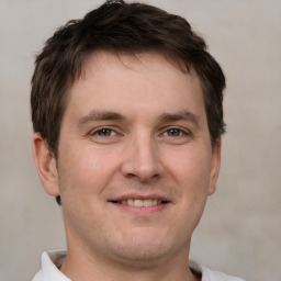 Joyful white young-adult male with short  brown hair and grey eyes