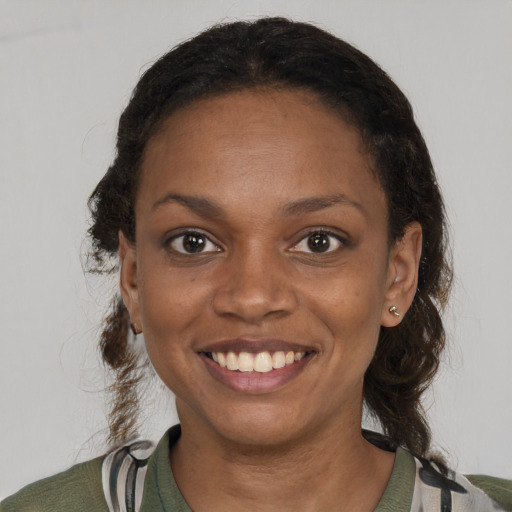 Joyful black young-adult female with medium  brown hair and brown eyes