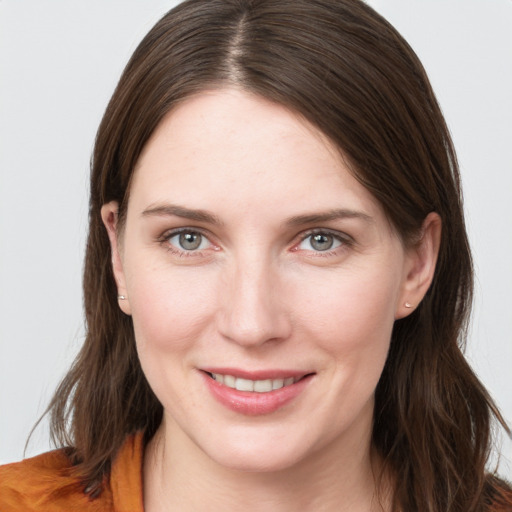 Joyful white young-adult female with medium  brown hair and grey eyes