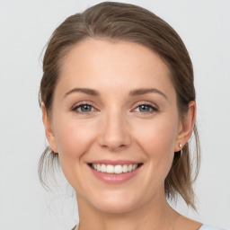 Joyful white young-adult female with medium  brown hair and grey eyes