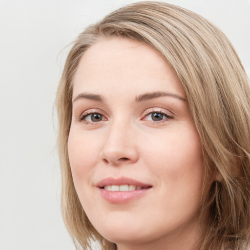 Joyful white young-adult female with long  brown hair and blue eyes