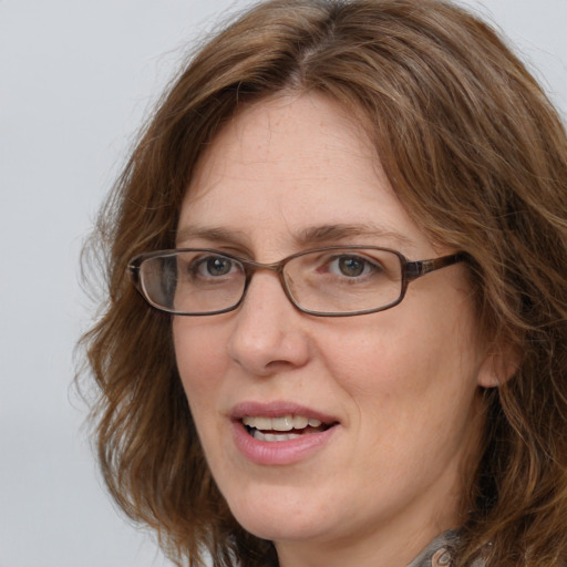 Joyful white adult female with medium  brown hair and blue eyes