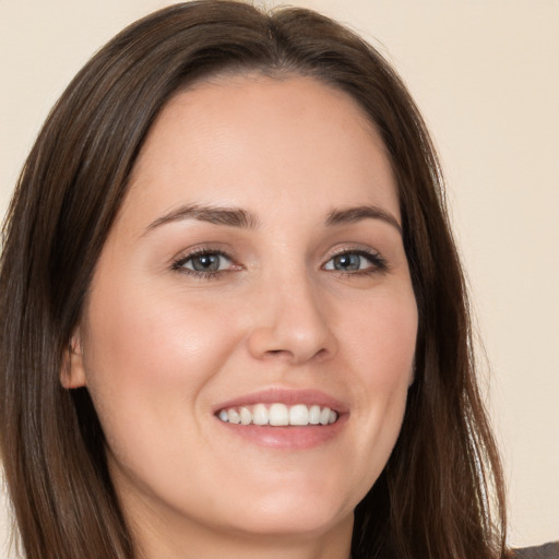 Joyful white young-adult female with long  brown hair and brown eyes