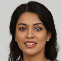 Joyful latino young-adult female with long  brown hair and brown eyes