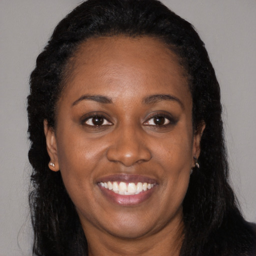 Joyful black young-adult female with long  black hair and brown eyes