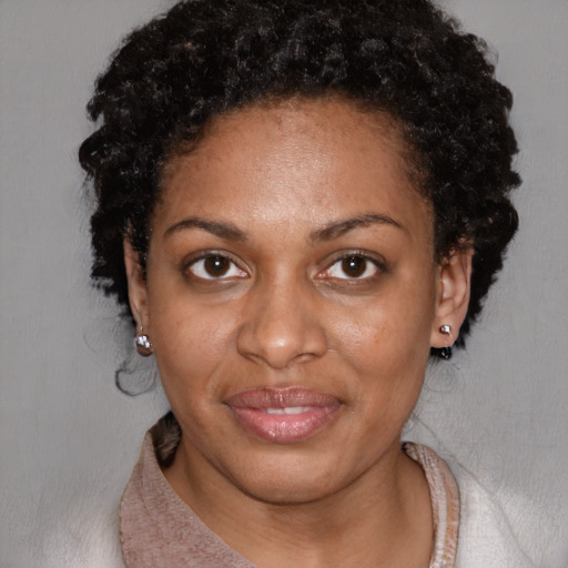 Joyful black adult female with short  black hair and brown eyes