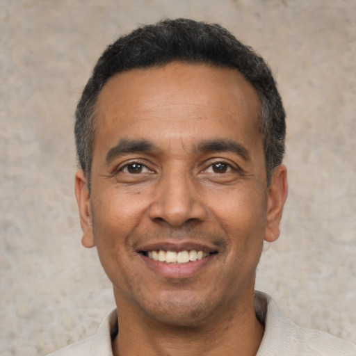 Joyful latino adult male with short  black hair and brown eyes