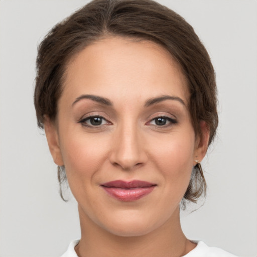 Joyful white young-adult female with medium  brown hair and grey eyes