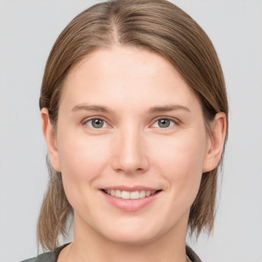 Joyful white young-adult female with medium  brown hair and grey eyes