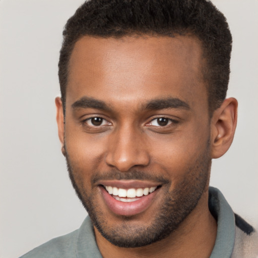 Joyful black young-adult male with short  brown hair and brown eyes