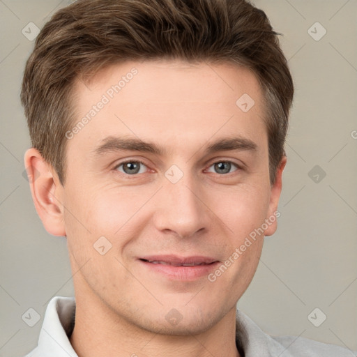 Joyful white young-adult male with short  brown hair and grey eyes