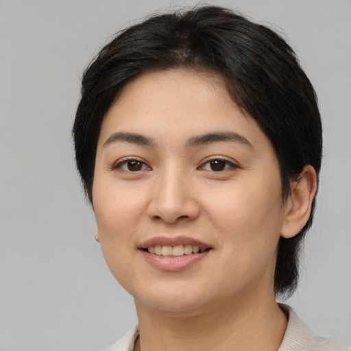 Joyful asian young-adult female with medium  brown hair and brown eyes