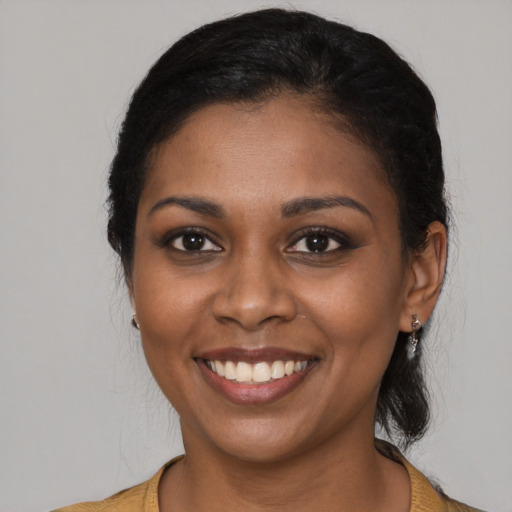 Joyful black young-adult female with medium  black hair and brown eyes