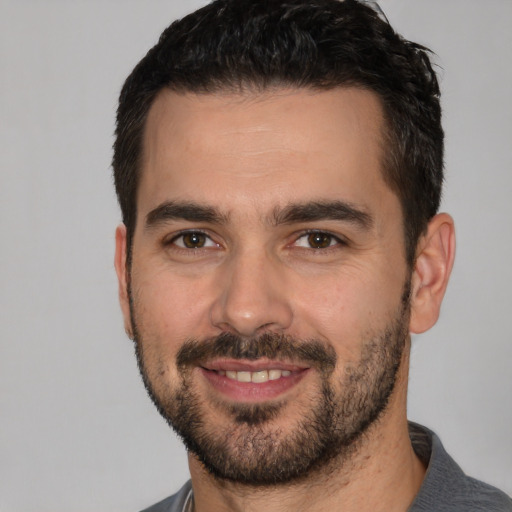 Joyful white young-adult male with short  black hair and brown eyes