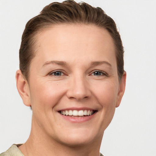 Joyful white adult female with short  brown hair and grey eyes